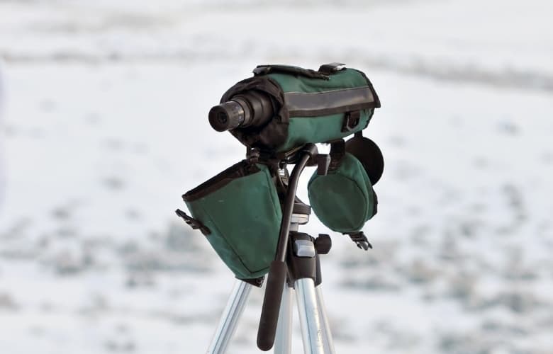 A monocular set up in the wilderness with cover to keep it safe