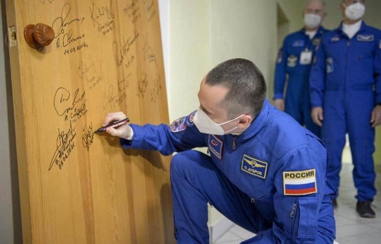 Expedition 65 Russian cosmonaut Pyotr Dubrov performs the traditional door signing at the Cosmonaut Hotel
